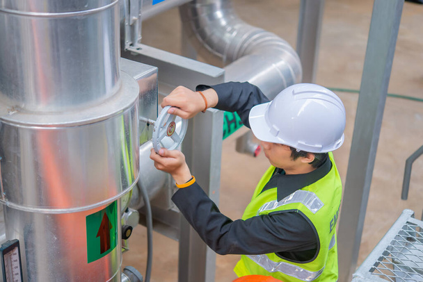 Asian Maintenance engineer at the waste water management system of a huge factory,maintenance checking technical data of heating system equipment,Thailand people - Foto, Imagen