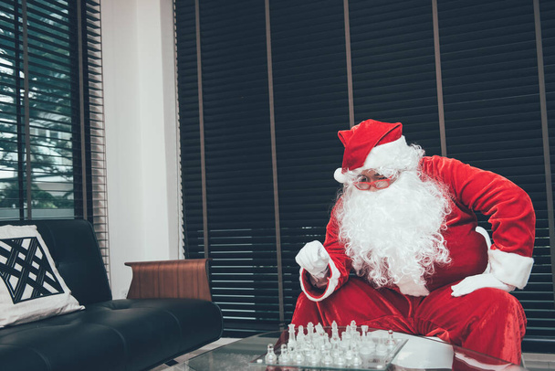 Lonely Santa Claus playing chess alone with sadness. - Zdjęcie, obraz