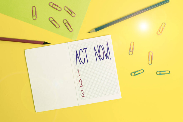 Writing note showing Act Now. Business photo showcasing do not hesitate and start working or doing stuff right away Blank squared notebook pencils markers paper sheet colored background. - 写真・画像