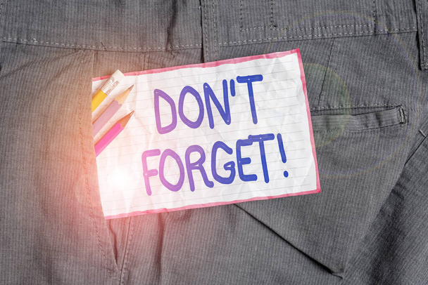 Text sign showing Don T Forget. Conceptual photo used to remind someone about important fact or detail Writing equipment and white note paper inside pocket of man work trousers. - Photo, Image