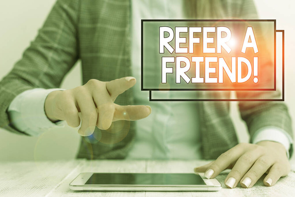 Writing note showing Refer A Friend. Business photo showcasing direct someone to another or send him something like gift Business woman sitting with mobile phone on the table. - Photo, Image