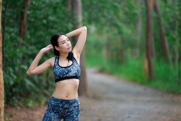 Азійська спортивна жінка розтягує тіло, дихає свіжим повітрям у парку, Таїланд, Фітнес і займається концепцією, бігає в парку, зігріває тіло - Фото, зображення