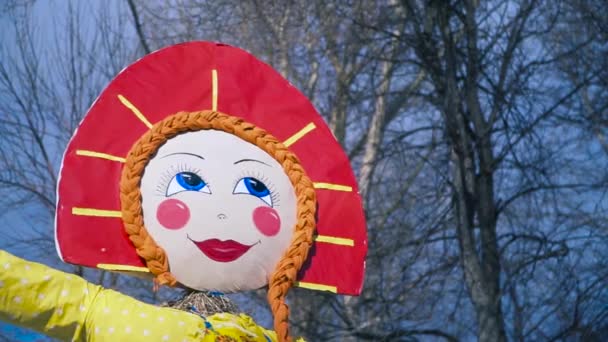 Slavic celebration of Shrovetide with a traditional Straw effigy prepared to be burnt. Clip. Bottom view of the female figure wearing red kokoshnik on blue sky background. - Footage, Video