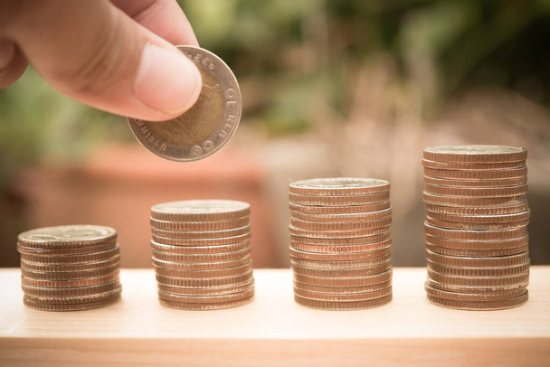 Close up of hand putting coins to stack, saving money concept - 写真・画像