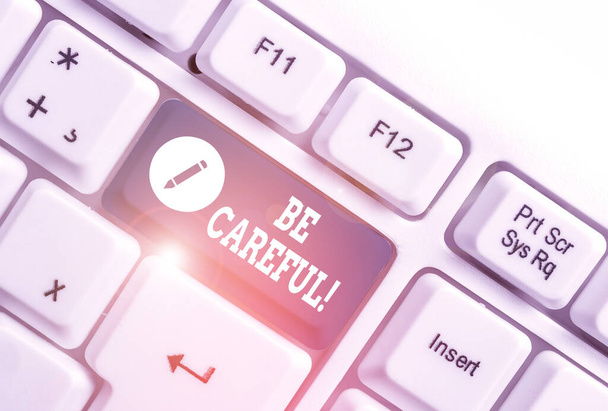 Conceptual hand writing showing Be Careful. Business photo text making sure of avoiding potential danger mishap or harm White pc keyboard with note paper above the white background. - Photo, Image