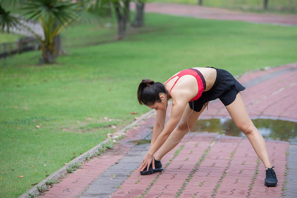 asiatische sportliche Frau streckt Körper atmet frische Luft im Park, Thailänder, Fitness- und Bewegungskonzept, Joggen im Park - Foto, Bild