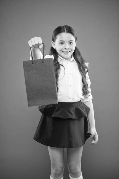 Buy school supplies. Back to school season. Girl holding shopping bag. Prepare for school season buy supplies stationery clothes in advance. School uniform formal style clothing. Enter first form - Photo, image