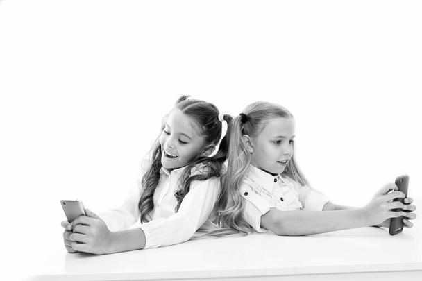 Bring the power of mobile learning into the classroom. Small children having lesson on mobile phones isolated on white. Little pupils using mobile devices in class. A fun mobile project - Fotó, kép
