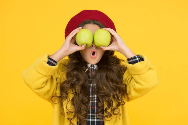 Impressing harvest. Girl cute long curly hair hold apples. Child girl emotional face expression. Delicious harvest. Harvest season. Child kid surprised face hold apples. Healthy food concept - 写真・画像
