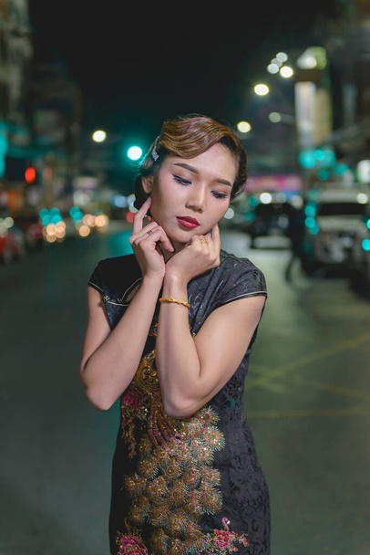 Portrait of asian woman in black dress on the road in downtown night scene,close up a girl street style - Foto, Bild