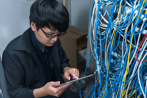 Inženýr s nářadím přijde do serverovny za prací, zkontroluje problém sítě, opraví server v serverovně, Thajci, Asiati - Fotografie, Obrázek