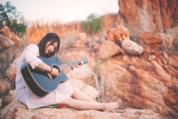 Portrait d'une femme bohème jouant de la guitare au coucher du soleil, Mode de vie d'une fille et d'un thailand moderne, Concept de femme heureuse, Personnes de Thaïlande - Photo, image