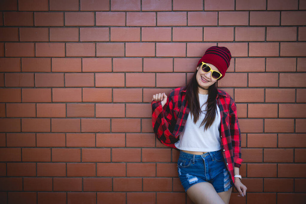 Portrait Asian hipster girl on brick wall background, lifestyle of Thailand people - Foto, Imagen