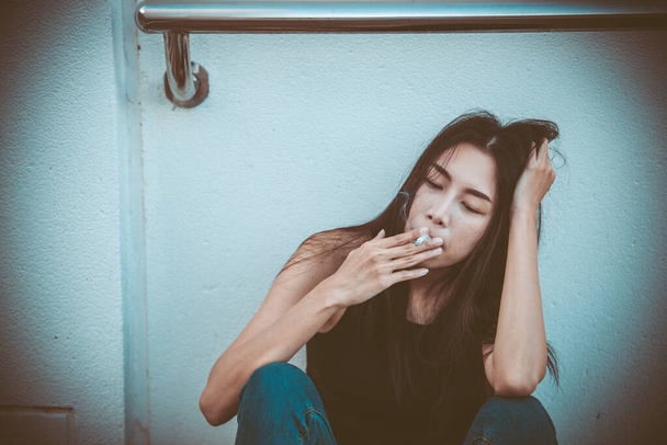 Азиатка грустит от любви, она курит, потому что стресс от бойфренда, женщина с разбитым сердцем
 - Фото, изображение