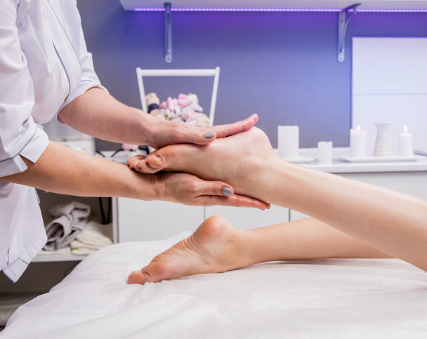 schöne junge Frau genießt Fußmassage im Wellness-Salon. Kosmetologie-Konzept - Foto, Bild
