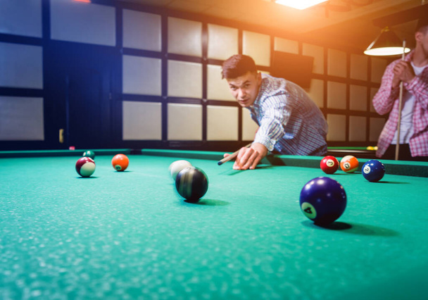 Young man trying to hit the ball in billiard. Pool background - Φωτογραφία, εικόνα