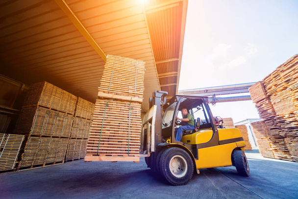 Forklift loader load lumber into a dry kiln. Wood drying in cont - Photo, image