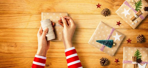 Person making Christmas gift boxes - 写真・画像
