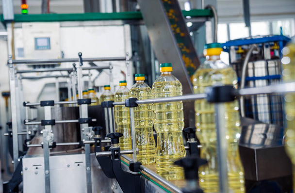 Linia do butelkowania oleju słonecznikowego w butelkach w zakładzie, koncepcja zaawansowanej technologii, tło przemysłowe  - Zdjęcie, obraz