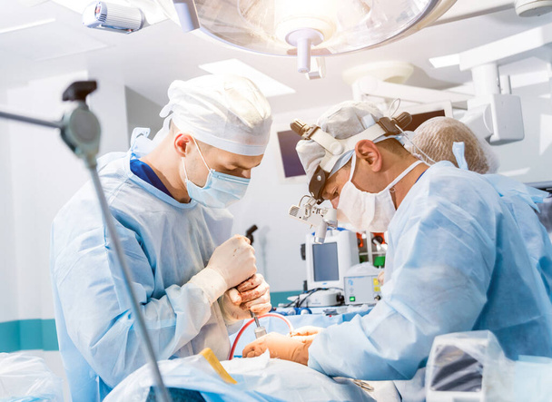 Spinal surgery. Group of surgeons in operating room with surgery equipment. Laminectomy. Modern medical background - Valokuva, kuva