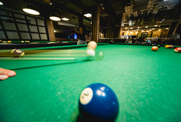 Young man trying to hit the ball in billiard. Pool background - Fotoğraf, Görsel