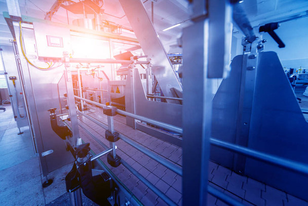 Bottellijn van zonnebloemolie in flessen bij fabriek, high-tech concept, industriële achtergrond  - Foto, afbeelding