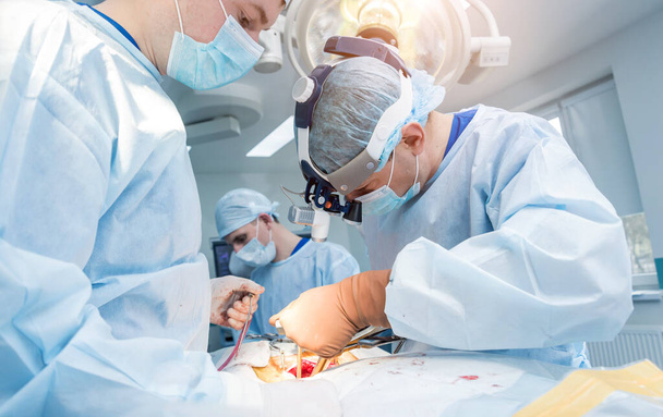 Spinal surgery. Group of surgeons in operating room with surgery equipment. Laminectomy. Modern medical background - Foto, Bild