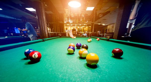 Young man trying to hit the ball in billiard. Pool background - Photo, Image