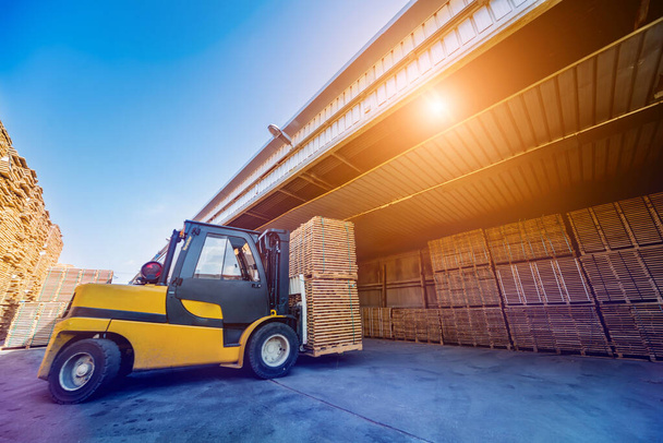 Forklift loader load lumber into a dry kiln. Wood drying in containers - Φωτογραφία, εικόνα