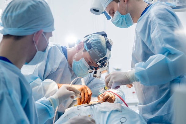 Spinale chirurgie. Groep chirurgen in operatiekamer met chirurgische apparatuur. Laminectomie. Moderne medische achtergrond - Foto, afbeelding