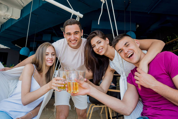Cheerful friends in the pub. Drinking beer, talking, having fun. Meeting friends after work - Foto, Bild