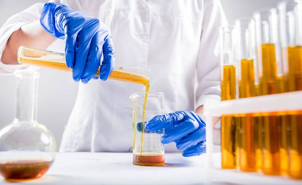Nahaufnahme eines Wissenschaftlers, der Bio-Öl eingießt. Schönheits- und Kosmetikwissenschaften - Foto, Bild