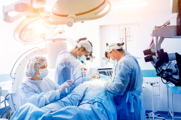 Spinal surgery. Group of surgeons in operating room with surgery equipment. Laminectomy. Modern medical background - Foto, Imagem