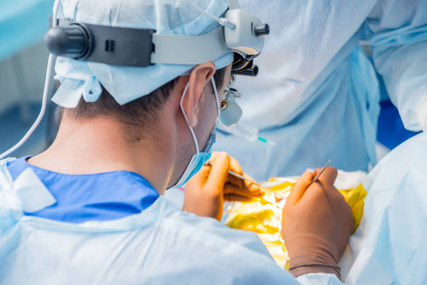 Brain surgery. Group of surgeons in operating room with surgery equipment. - Foto, afbeelding
