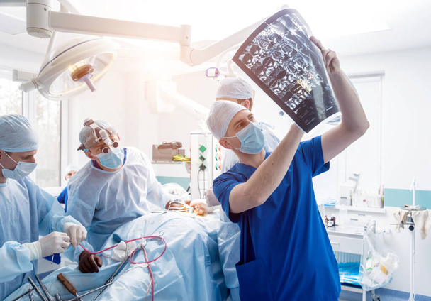 Chirurgia spinale. Gruppo di chirurghi in sala operatoria con attrezzature chirurgiche. Laminectomia. Contesto medico moderno
 - Foto, immagini