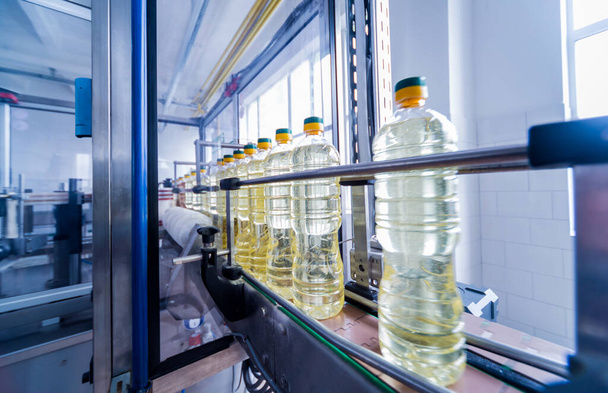 Linha de engarrafamento de óleo de girassol em garrafas na planta, conceito de alta tecnologia, fundo industrial
  - Foto, Imagem