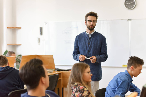 Male professor explain lesson to students and interact with them - Photo, Image