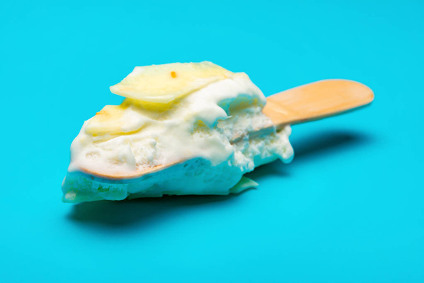 mostly eaten white chocolate outer popsicle on blue background - Fotó, kép