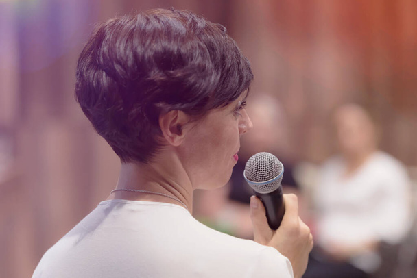 Όμορφη επιχειρηματίας γυναίκα με μικρόφωνο στο χέρι μιλώντας στο - Φωτογραφία, εικόνα