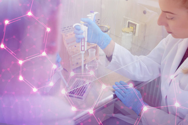 Dos jóvenes científicos de laboratorio que trabajan en el laboratorio con tubos de ensayo a - Foto, Imagen