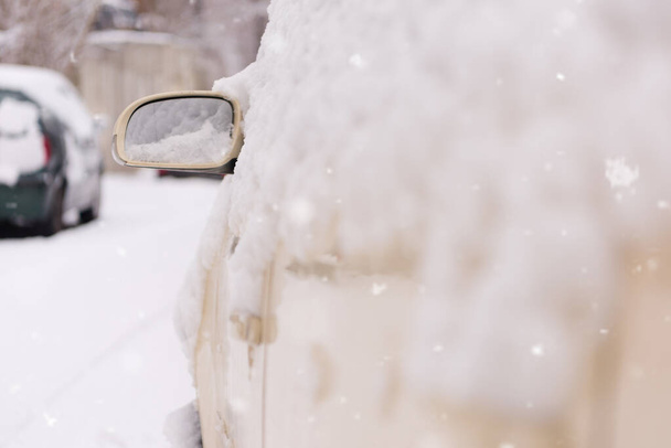 Στην πλευρά του δρόμου, παρκαρισμένα αυτοκίνητα καλυμμένα με χιόνι. Αυτοκίνητο κάτω από το χιόνι - Φωτογραφία, εικόνα