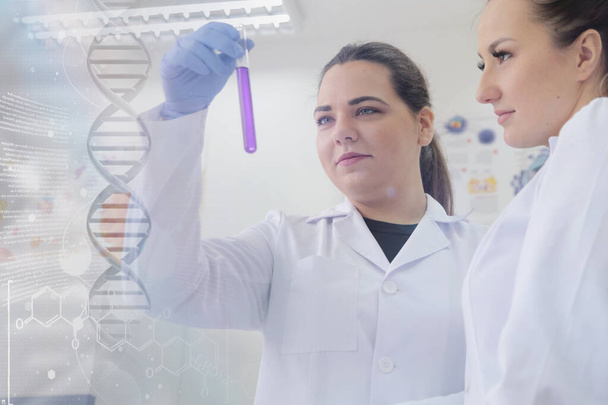 Две молодые женщины-лаборантки работают в лаборатории с тестами  - Фото, изображение