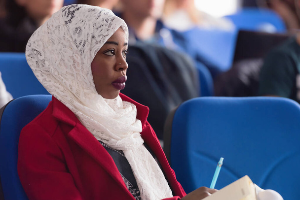 Kaunis nainen afro hijab muslimi opiskelija kuunnella tarkasti dur
 - Valokuva, kuva