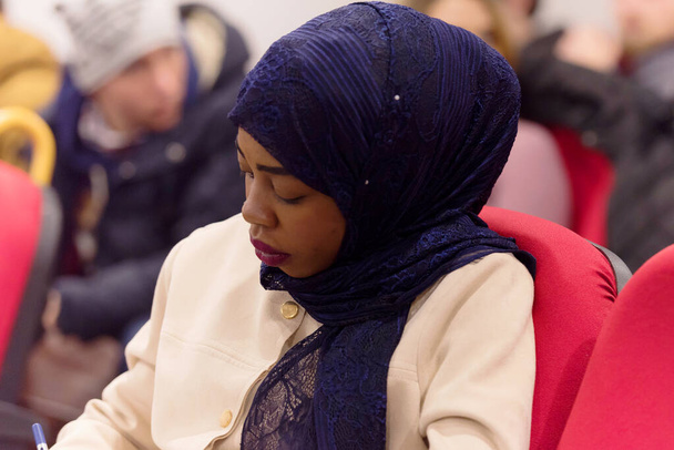 美しい女性アフロ・ヒジャーブイスラム教徒学生聞きます慎重にドゥール - 写真・画像