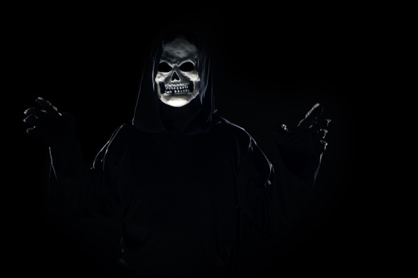 Scary monster or grim reaper ghost coming out of the dark shadows to haunt during Halloween.  Depicts a scary and deadly fictitious demon - Photo, Image