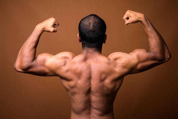 Rear view of muscular Indian man with mustache shirtless - Photo, Image