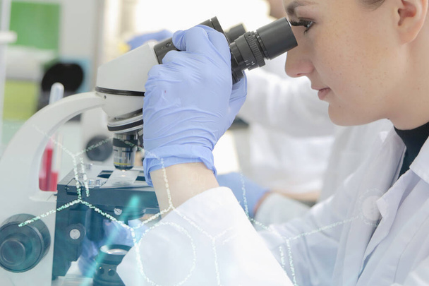 Młoda kobieta naukowiec patrząc przez mikroskop w laborat - Zdjęcie, obraz