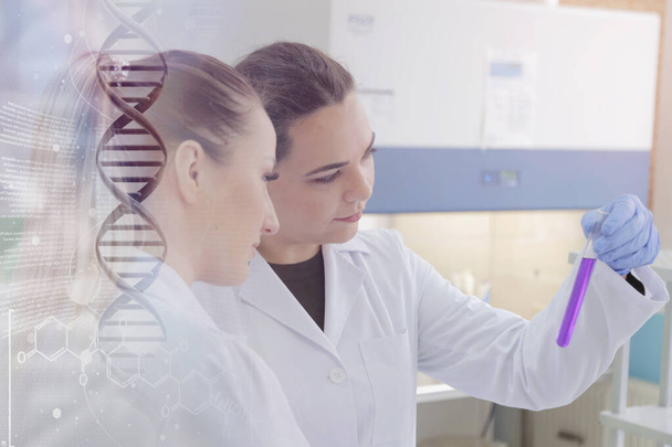 Twee jonge vrouwelijke laboratoriumwetenschappers werken in het lab met een test  - Foto, afbeelding