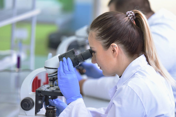 Двоє молодих жінок і чоловіків Лабораторні вчені працюють в лабораторії
 - Фото, зображення