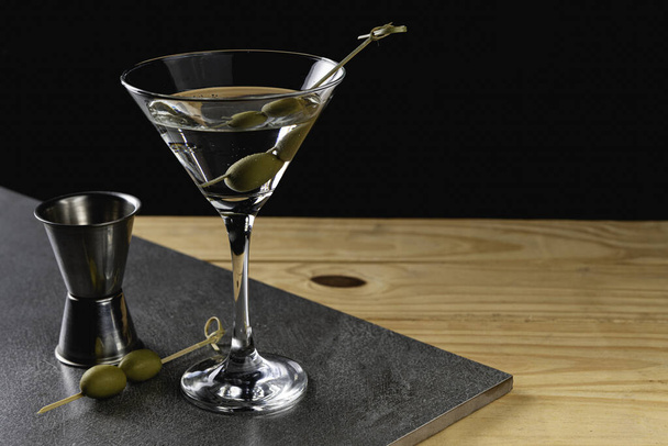 Trinken Sie trockene Martini mit grünen Oliven auf Steinhintergrund. - Foto, Bild